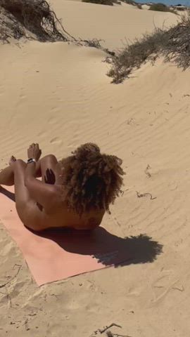 Naked ebony model doing yoga in the desert